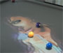 Un  tapis de billard sur lequel est projete une image suivant le mouvement des boules