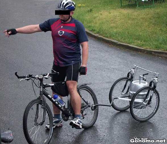 Un vrai sportif sur son vtt et son fu de biere qui le suit de pres ...