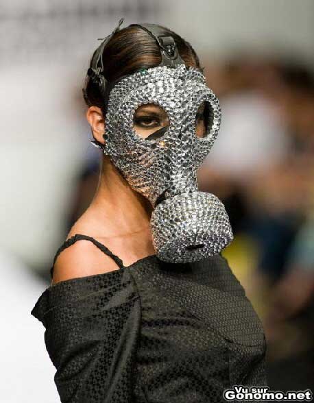 Une mannequin defile sur un podium avec un masque a gaz plutot special