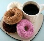 Une bonne tasse de cafe accompagnee de quatres gros donuts en laine a tricoter
