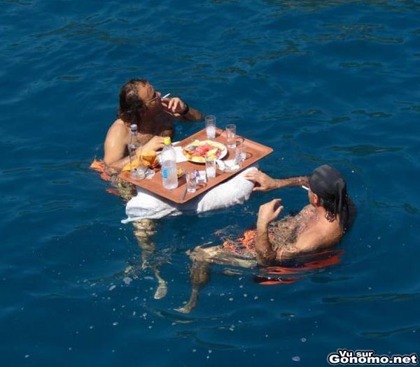 Deux gars dejeunent tranquillou installes au milieu d un lac avec leur plateau repas