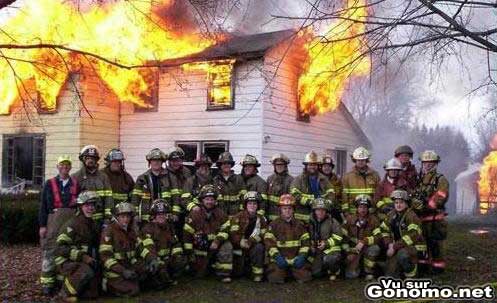 Des pompiers posent pour la photo de classe devant le feu d une maison en train de se propager