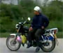 Un chinois a la cool en amazone sur sa moto circule tranquillement dans le traffic routier