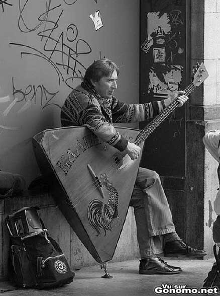 Un musicien de rue qui joue avec une enorme guitare