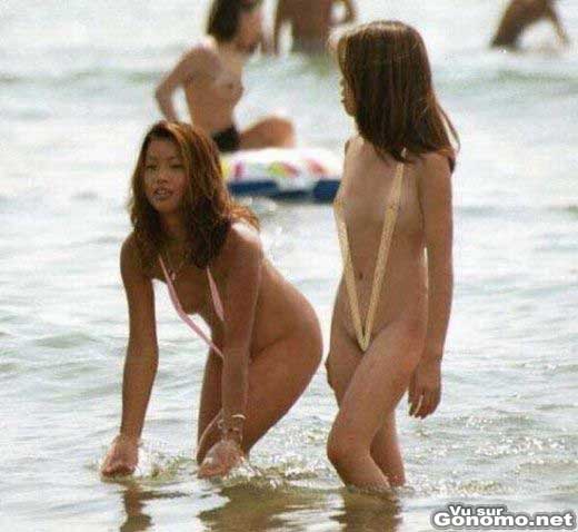 Deux belles asiatiques a la mer a moitie a poil avec leurs maillots de bain tres minimalistes