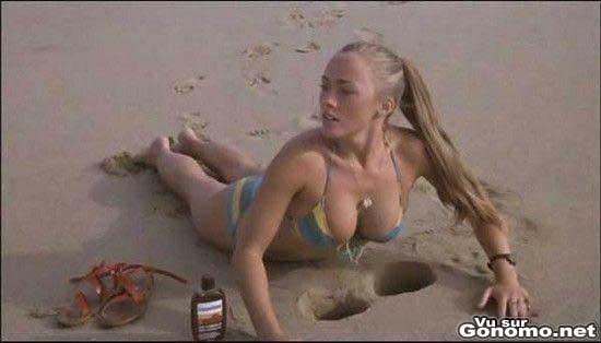 Elle garde ses seins aux frais dans le sable