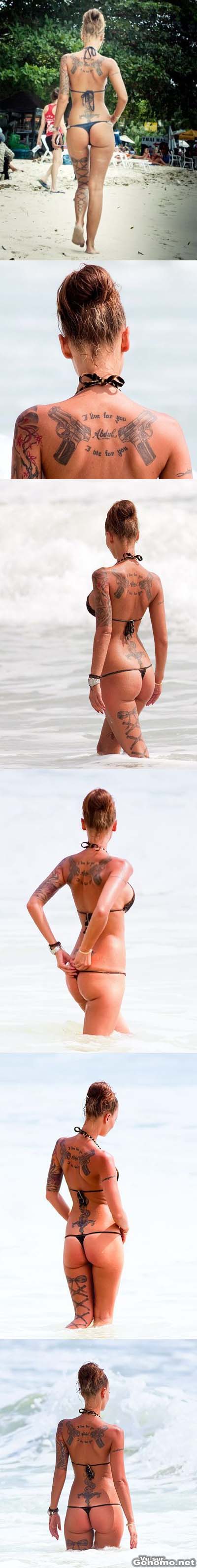 Femme tatouee : sympathique cette brune tatouee avec son bikini qui lui rentre dans les fesses