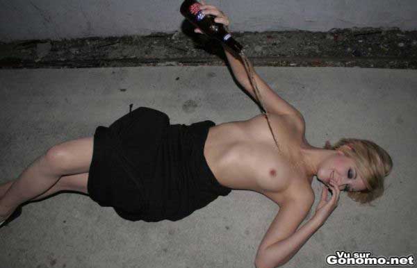 Une blonde topless finit sa soiree arrosee par une petite douche a la biere sur le bitume ...