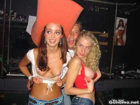 Une fille, avec un super chapeau, et sa copine montrent leurs seins en soiree