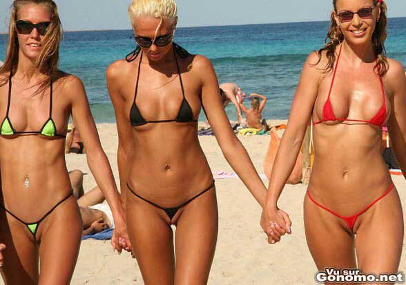 Trois belles jeunes femmes se baladent sur la plage en micro bikini