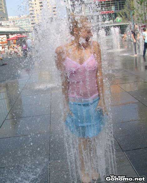 Cette fille n a pas peur de se mouiller et profite donc de cette fontaine pour se rafraichir