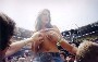 Une fille topless portee sur les epaules d un mec se fait tater les seins par la foule dans un stade