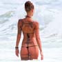 Femme tatouee : sympathique cette brune tatouee avec son bikini qui lui rentre dans les fesses
