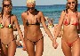 Trois belles jeunes femmes se baladent sur la plage en micro bikini