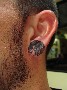 Un petit visage de femme tatoue sur le lobe de cette oreille